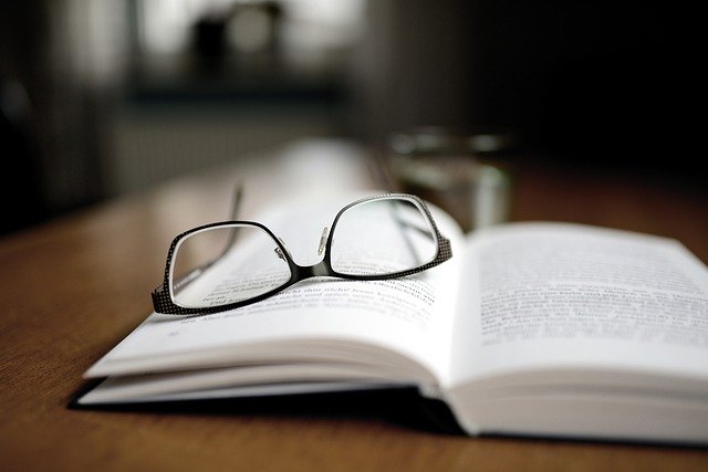 Symbolbild Wahrnehmbarkeit - Brille ist auf einem Buch abgelegt